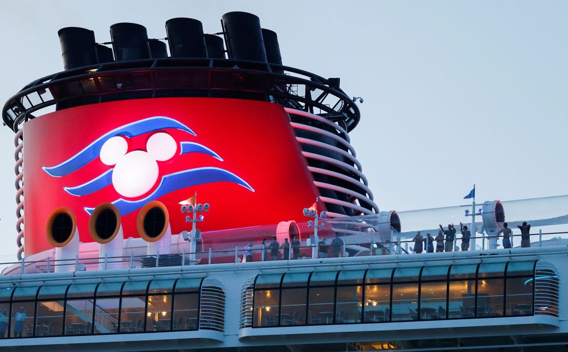 Passengers stand on the deck of Disney Dream, a Disney Cruise Lines' ship, as it sails to the Bahamas on August 9, 2021.