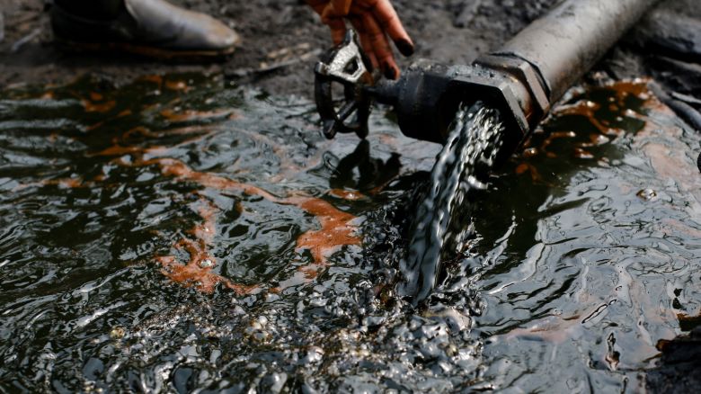 A person operates a tap of crude oil during the destruction of an illegal camp, in Okrika, Rivers state, Nigeria on January 28, 2022.