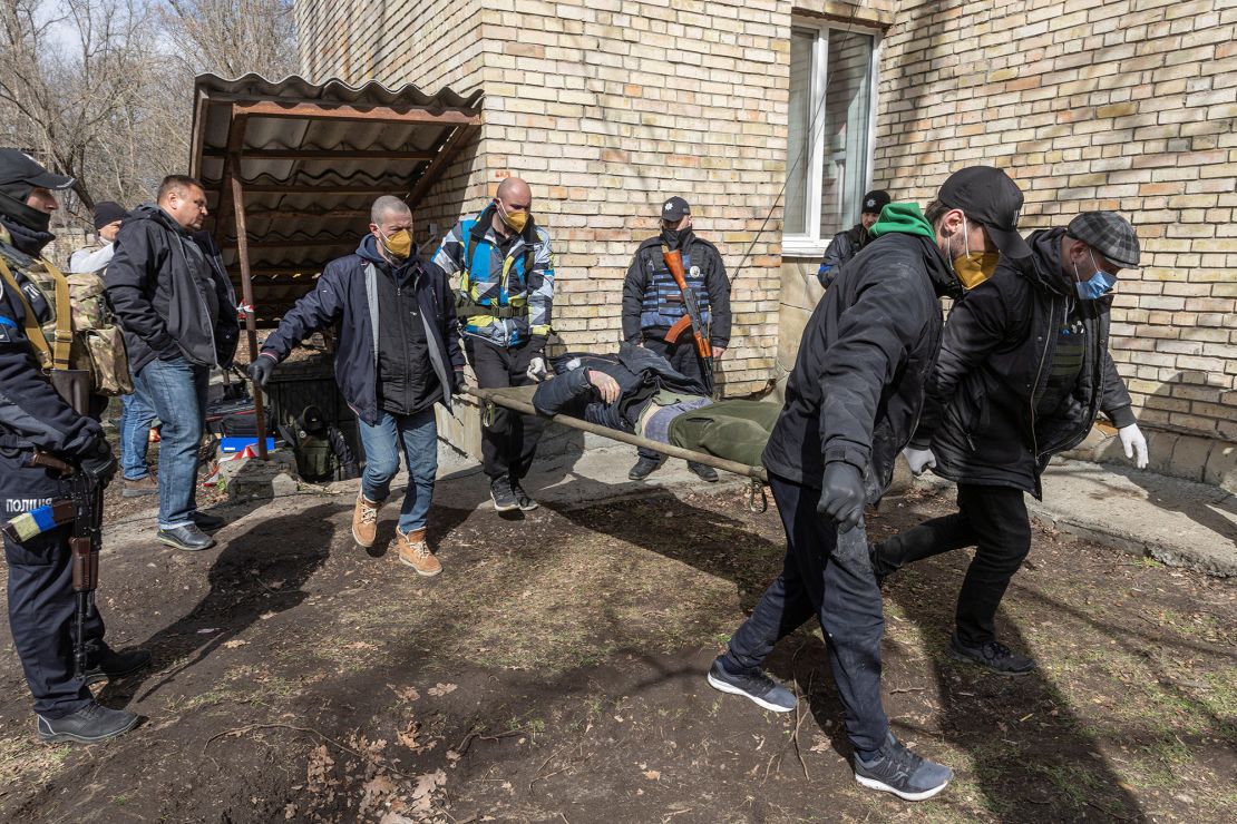 Ukrainian servicemen carry a dead body found in a basement in the town of Bucha on April 4.