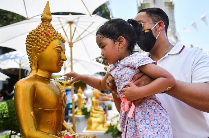 <strong>Holiday rituals: </strong>A girl pours water on a Buddha statue during the Songkran holiday, a ritual known as Song Nam Phra.
