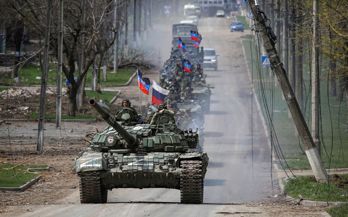 A convoy of Russian troops moves along a road in the occupied Ukrainian city of Mariupol on April 21, 2022.