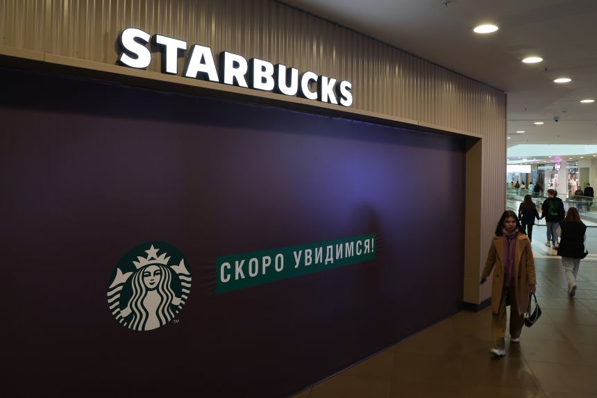 A woman walks past a closed Starbucks cafe in central Saint Petersburg, Russia in May 2022.