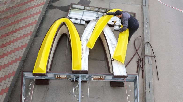 A worker dismantles a pair of golden arches while removing the logo signage from a McDonald's in the town of Kingisepp, in the Leningrad region of Russia, on June 8, 2022.