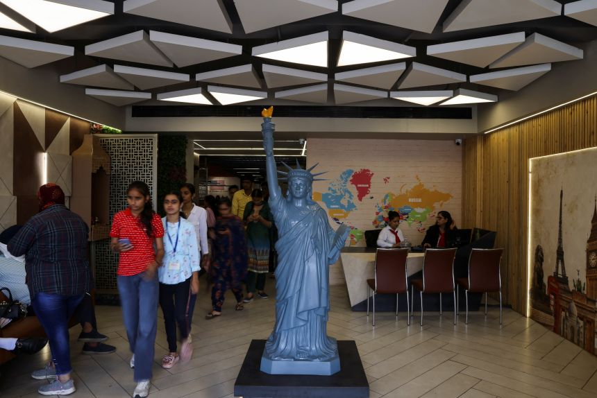 Students walk in the lobby of Western Overseas, an institute providing coaching for English language proficiency tests and visa consultancy in Ambala, India.