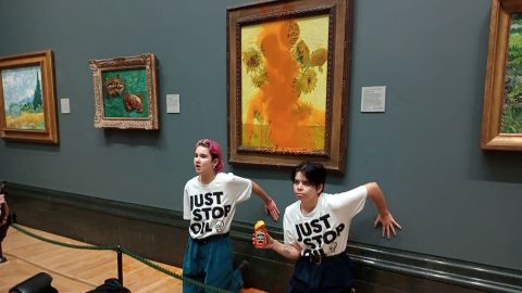 Activists of "Just Stop Oil" glue their hands to the wall after throwing soup at a van Gogh's painting "Sunflowers" at the National Gallery in London, Britain October 14, 2022. Just Stop Oil/Handout via REUTERS    THIS IMAGE HAS BEEN SUPPLIED BY A THIRD PARTY. MANDATORY CREDIT