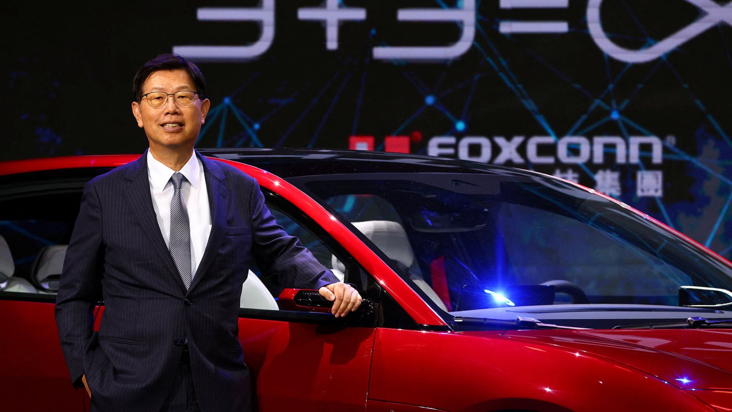 Foxconn Chairman Young Liu poses on stage with an electric vehicle, the Model C, during the company's annual Tech Day in Taipei, Taiwan, on October 18, 2022.