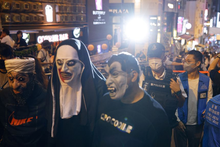 A policeman with a torch warns against gatherings during Halloween at Lan Kwai Fong in Hong Kong on October 31, 2022.