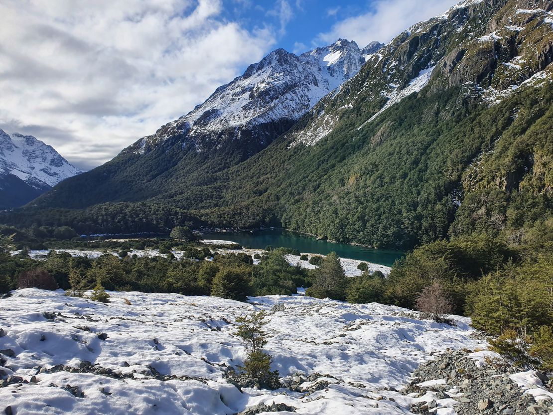 The alpine lake is surrounded by steep forests.