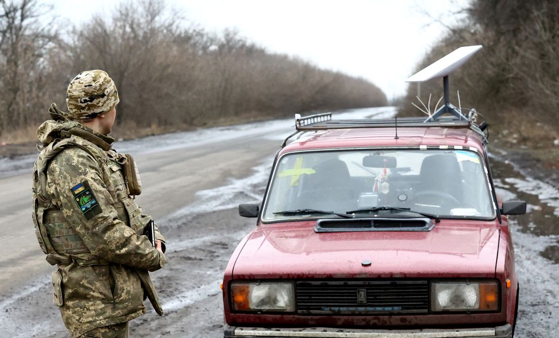 A Ukrainian serviceman stands next to a vehicle that carries a Starlink satellite internet system near the front line in Donetsk region, Ukraine, on February 27, 2023.