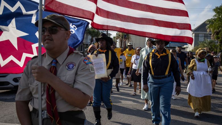 Trooper Jackie Quinn, representing "Buffalo Soldiers" of the 9th and 10th Cavalry, carries the General Order No. 3 during a march reenactment in celebration of Juneteenth in Galveston, Texas, U.S., June 19, 2023. REUTERS/Adrees Latif