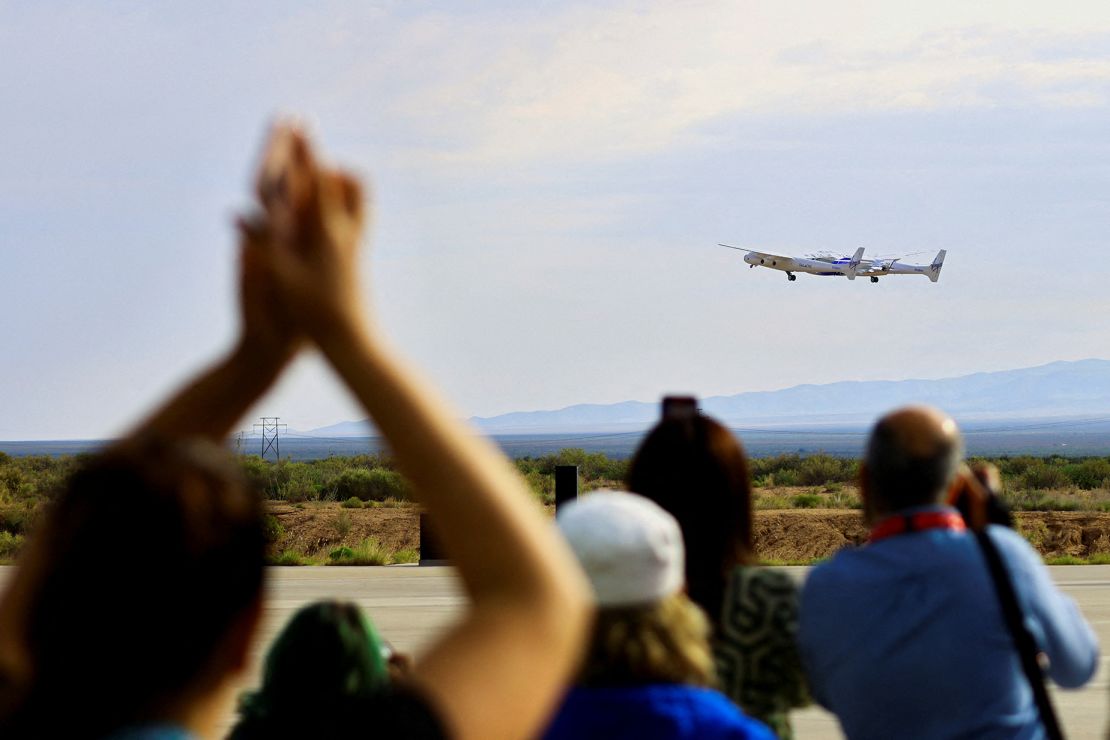 2023年6月29日、ニューメキシコ州スペースポート・アメリカの施設で、ヴァージン・ギャラクティック社が運航するロケット旅客機が同社初の商用飛行中に離陸すると人々が反応する。