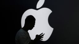 A man check his phone near an Apple logo outside its store in Shanghai, China September 13, 2023.