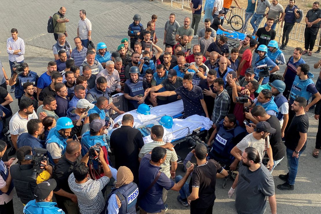 Mourners carry the bodies of Palestinian journalists Mohammed Soboh and Saeed Al-Taweel, killed when an Israeli missile hit a building while they were reporting, in Gaza City, on October 10.
