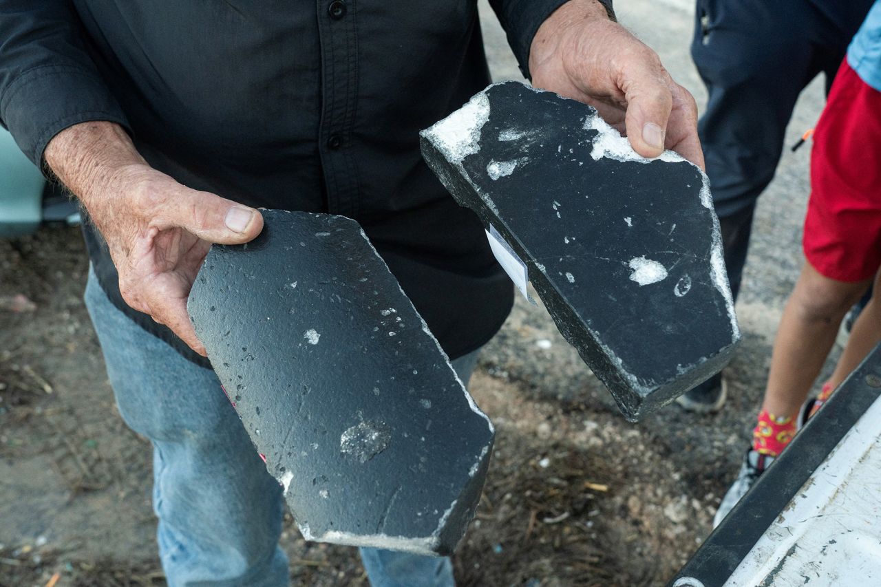 Ron Parker holds pieces of heat shield tiles he found after the first test launch of Space X's Starship in Boca Chica, Texas, in April 2023.