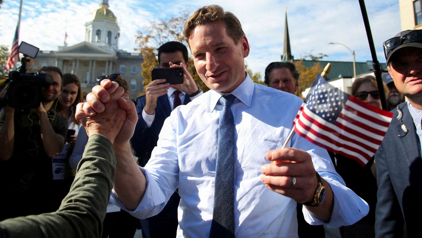 Dean Phillips holds hands with a supporter outside the statehouse in Concord, New Hampshire, on October 27. 