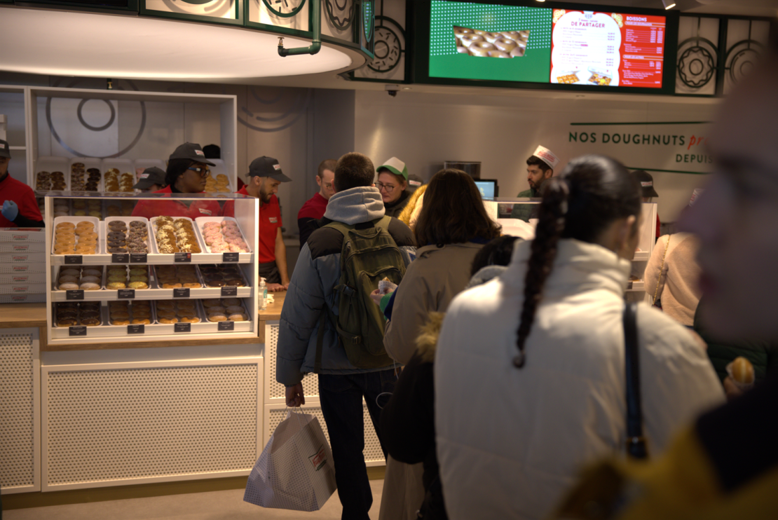People line up to buy donuts inside the newly-opened Krispy Kreme in Châtelet–Les Halles, Paris, on December 7.