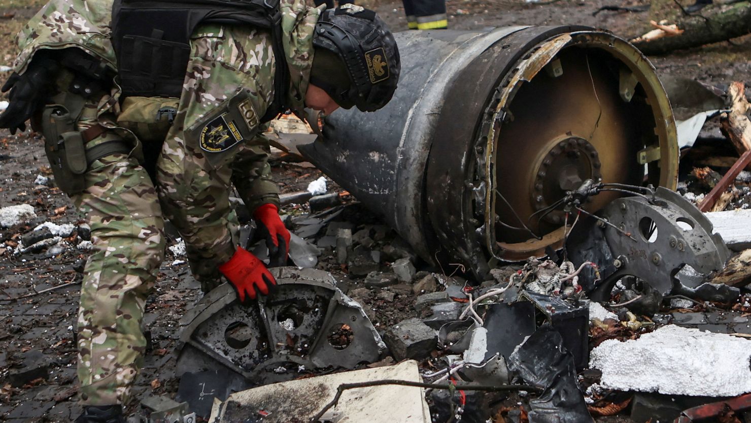 A bomb squad member works next to remains of an unidentified missile after residential buildings were heavily damaged during a Russian attack in central Kharkiv, Ukraine, on January 2, 2024.