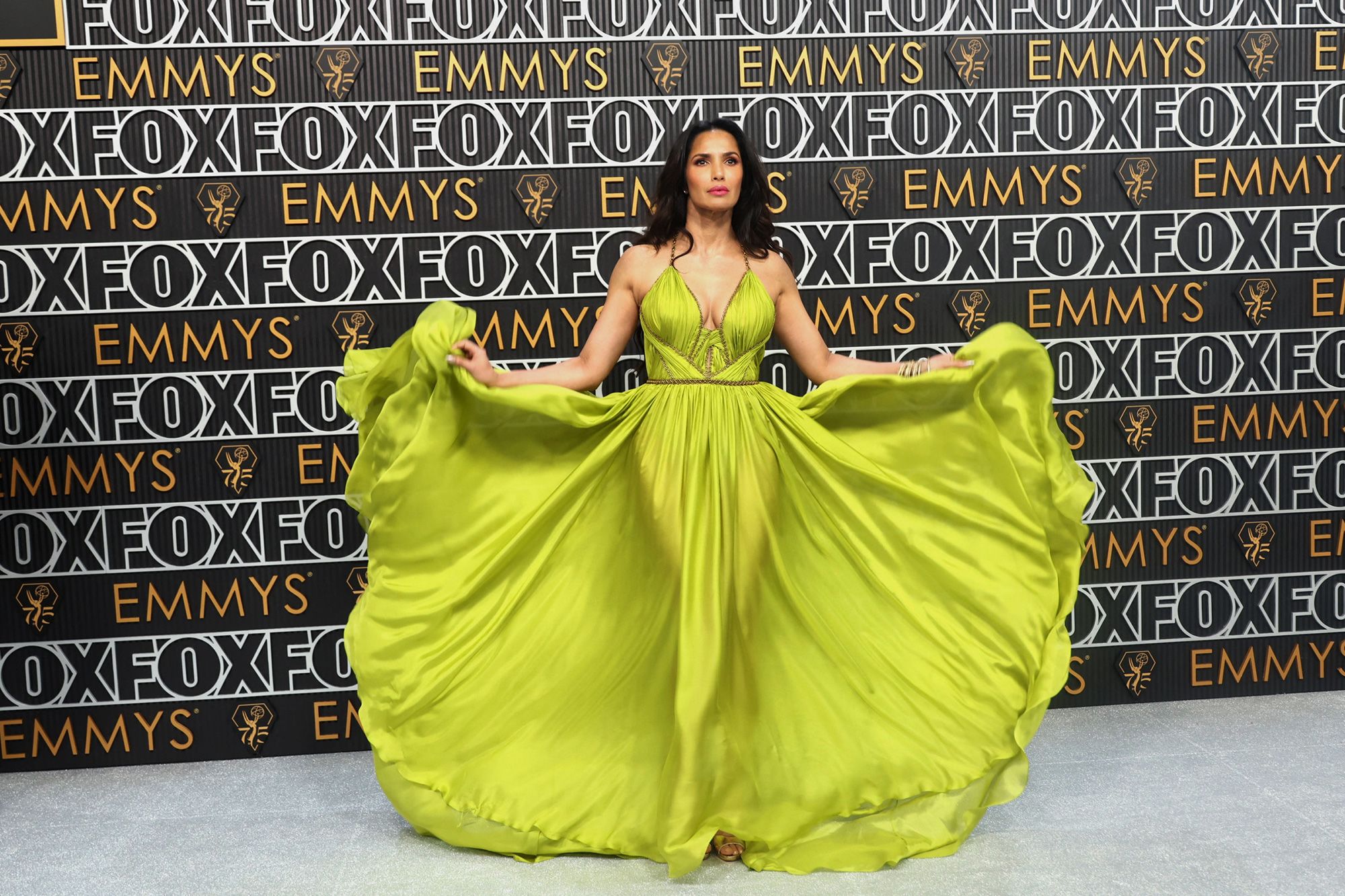 Television host Padma Lakshmi arrives in a neon green goddess gown with gold bodice trimming by New York label Marchesa.