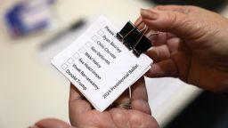 Sharon McNutt holds paper ballots before Republican caucus voters arrive to choose a presidential candidate, in Silver City, Iowa, on Monday.