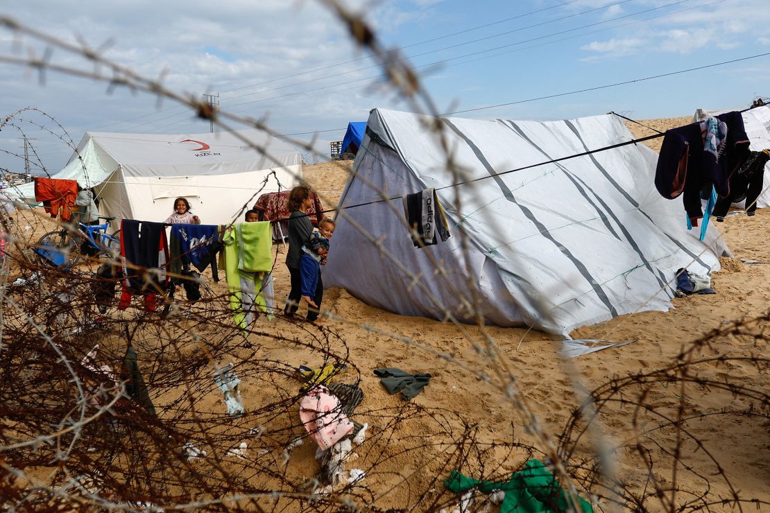 Children stand next to tents as displaced Palestinians, who fled their houses due to Israeli strikes, shelter in Rafah, in the southern Gaza Strip on January 26.