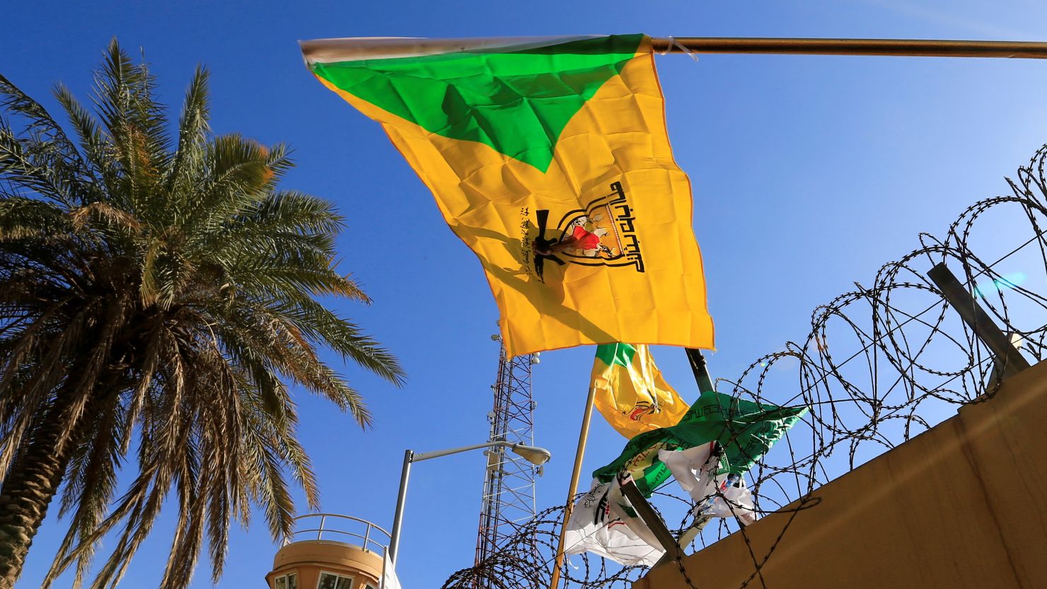 The Kataib Hezbollah militia group's flag flies at a protest outside the US Embassy in Baghdad, Iraq, in 2019.