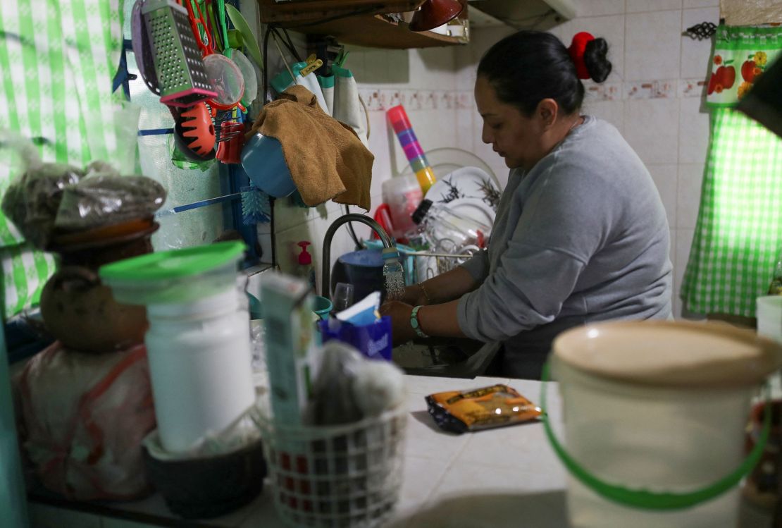 A woman washes the dishes in her home after receiving a free distribution of water in the Iztapalapa neighborhood on January 31, 2024.