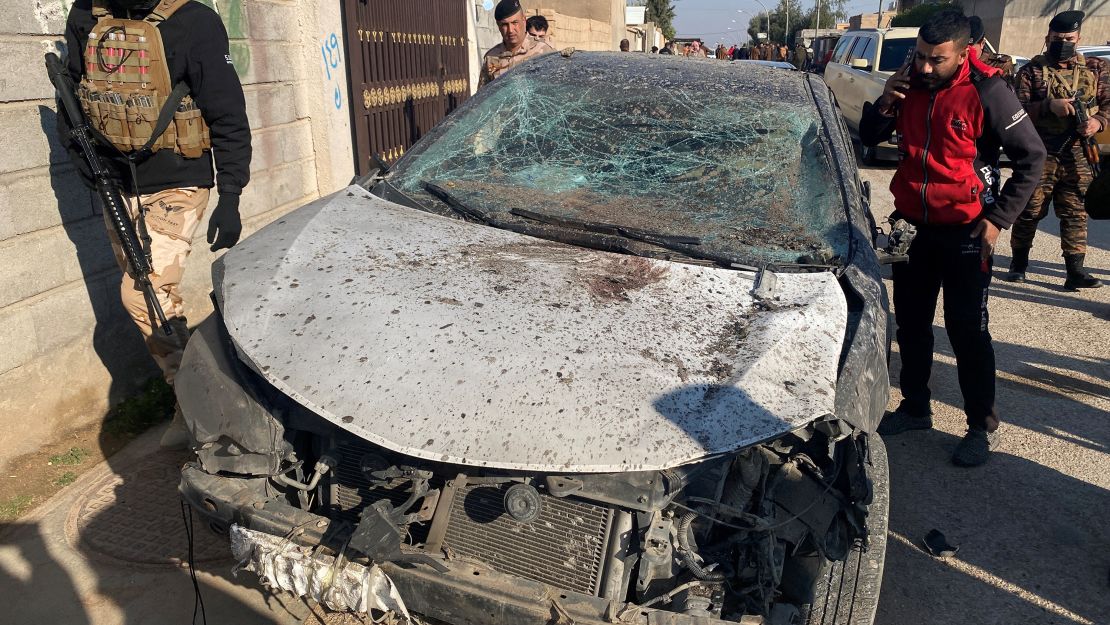 Security forces inspect a damaged car at the site of a US airstrike in Al Qaim, Iraq, February 3, 2024.
