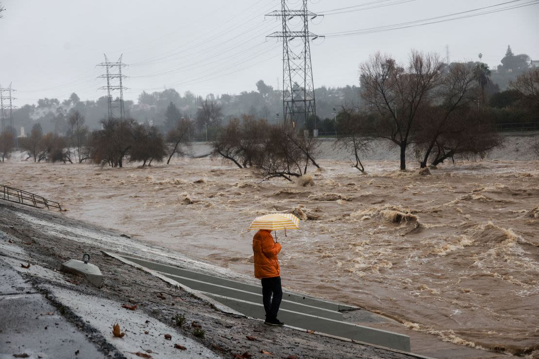 Una persona con un paraguas observa el río de Los Ángeles durante unas fuertes lluvias en Los Ángeles, California, el 5 de febrero de 2024.