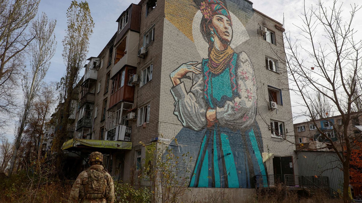 A Ukrainian serviceman passes a damaged residential building in the front line town of Avdiivka, in November.