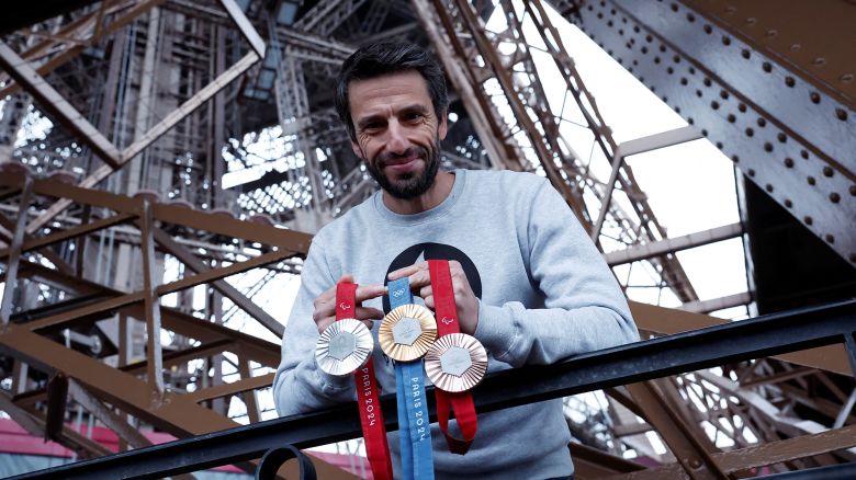 Tony Estanguet, president of the Paris 2024 Olympics organizing committee, poses with Olympic and Paralympic Games medals on the Eiffel Tower.