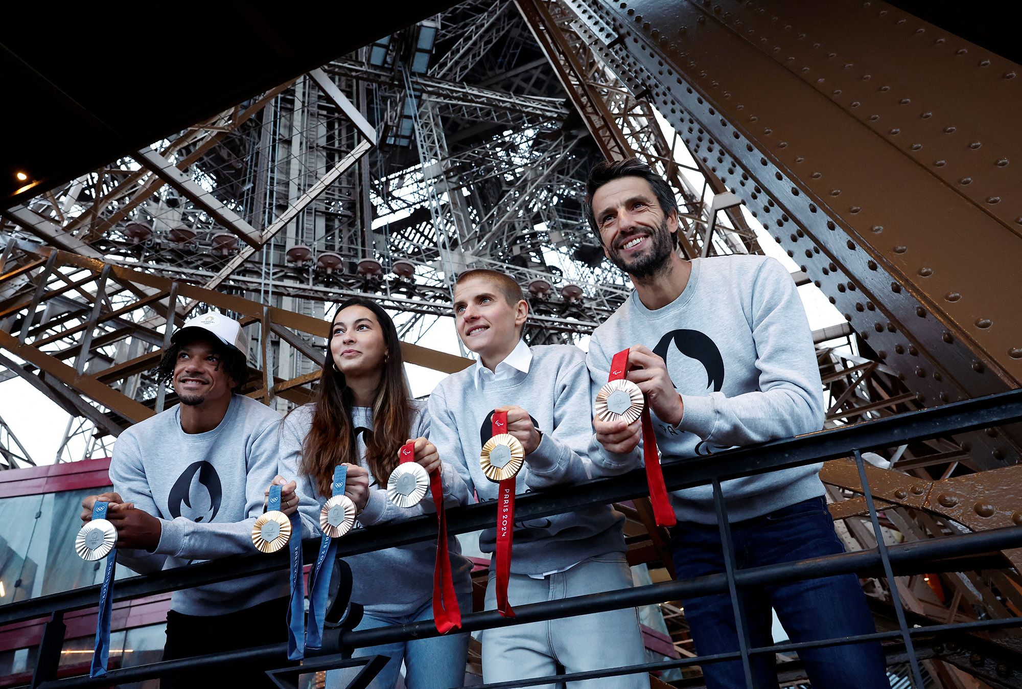 From right: Tony Estanguet, president of the Paris 2024 Olympics organising committee on the Eiffel Tower with French cyclist Marie Patouillet, fencer Sara Balzer and athlete Arnaud Assoumani holding Olympic and Paralympic Games medals.