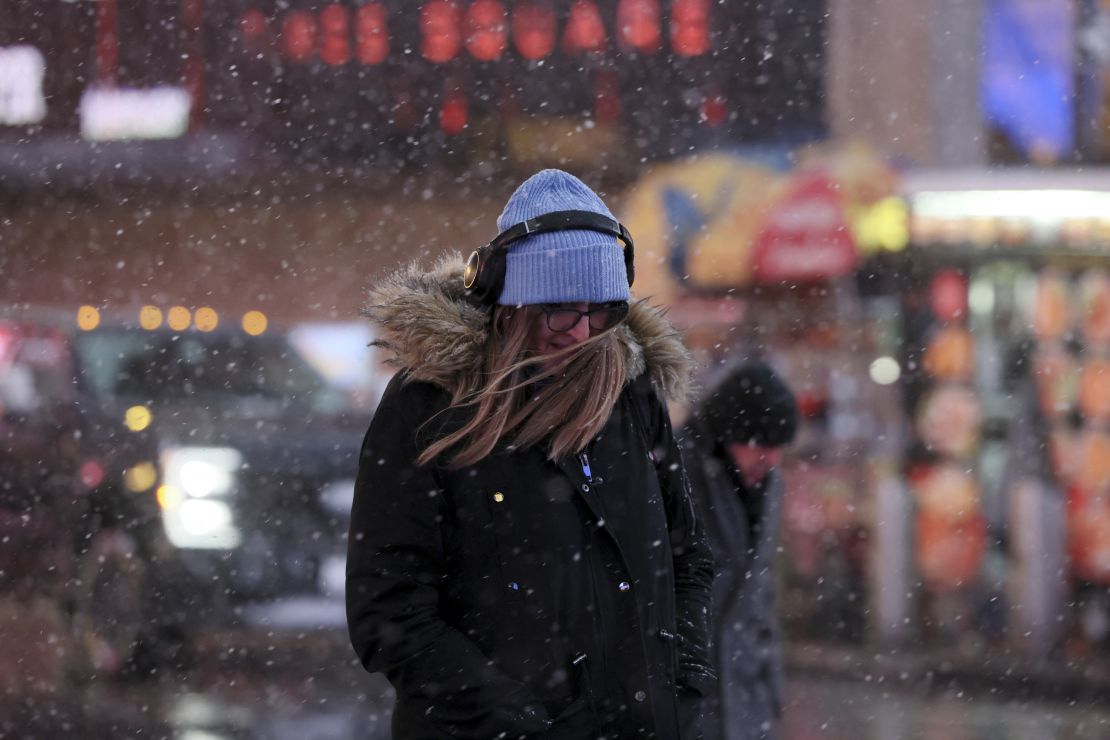 A morning commuter makes her way through wind and snow in New York on Tuesday.