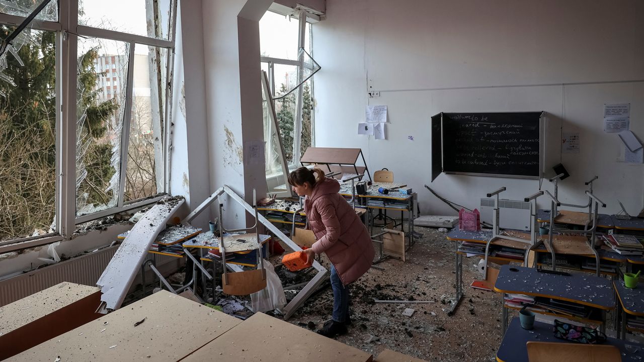 A woman inspects damage to a school in Lviv following Russian attacks on Thursday.