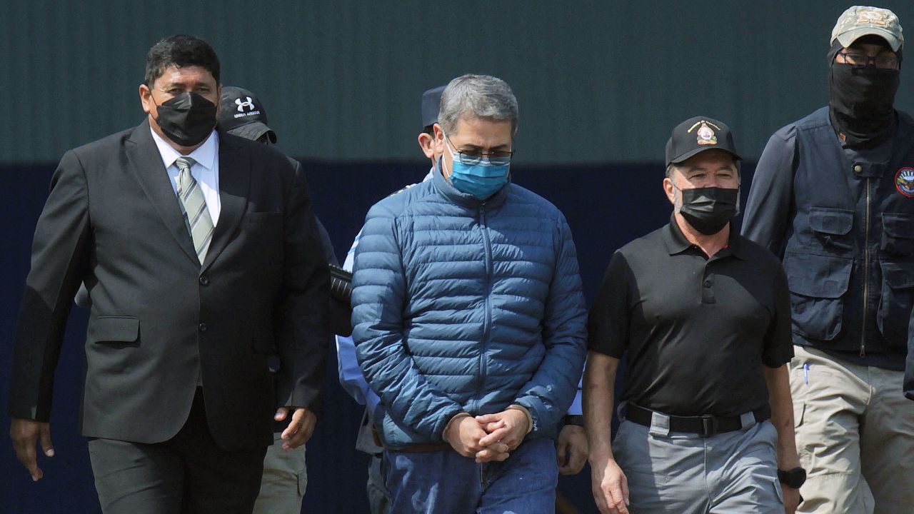 FILE PHOTO: Honduras former President Juan Orlando Hernandez is escorted by authorities as he walks towards a plane of the U.S. Drug Enforcement Administration (DEA) for his extradition to the United States, to face a trial on drug trafficking and arms possession charges, at the Hernan Acosta Mejia Air Force base in Tegucigalpa, Honduras April 21, 2022. REUTERS/Fredy Rodriguez/File Photo