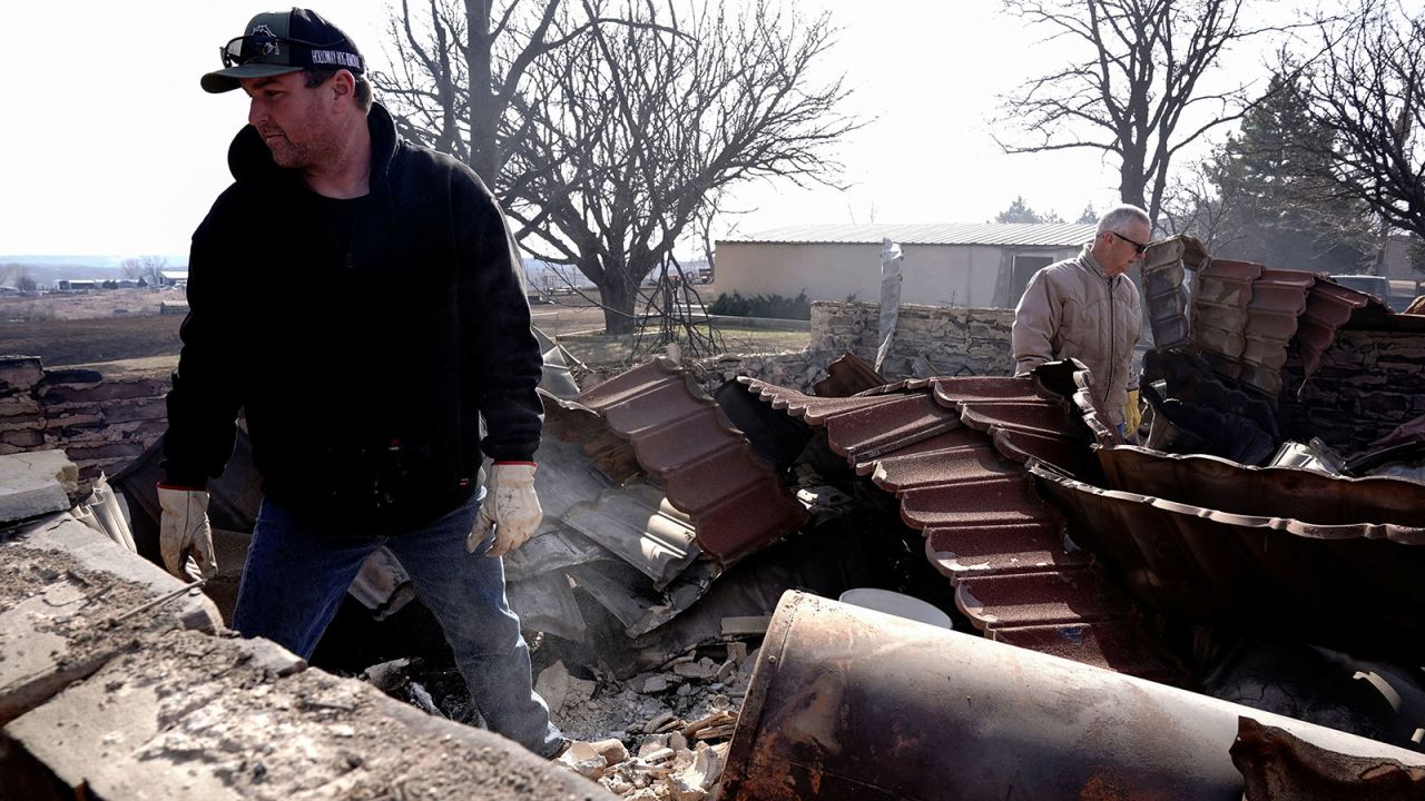 Mason Holloway and Hugh Lively look through the remains of a relatives home that was destroyed by the Smokehouse Creek wildfire in Canadian, Texas, U.S. February 28, 2024.  REUTERS/Nick Oxford