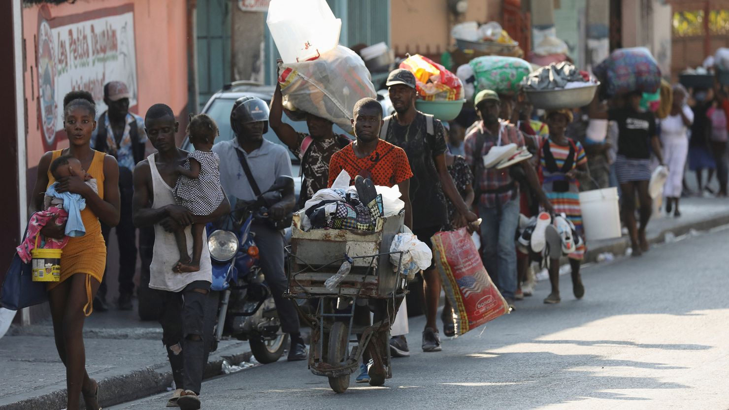 People flee their homes as police confront armed gangs in Port-au-Prince, Haiti, on February 29.