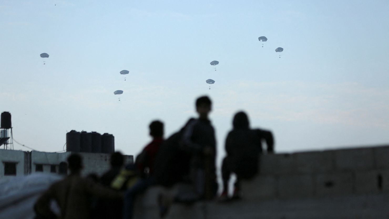 Palestinians watch as the US military air drops aid over Gaza on March 2, 2024.