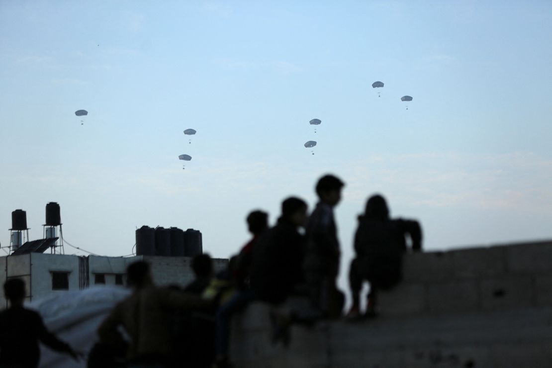 People watch as U.S. forces drop emergency relief over Gaza on March 2, 2024.