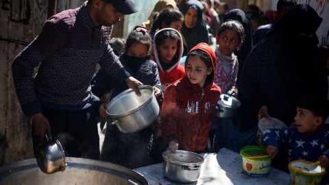 Palestinian children wait to receive food distributed by a charity kitchen, in the southern city of Rafah, on March 5. Israel's military campaign in Gaza has consigned civilians to deadly starvation.