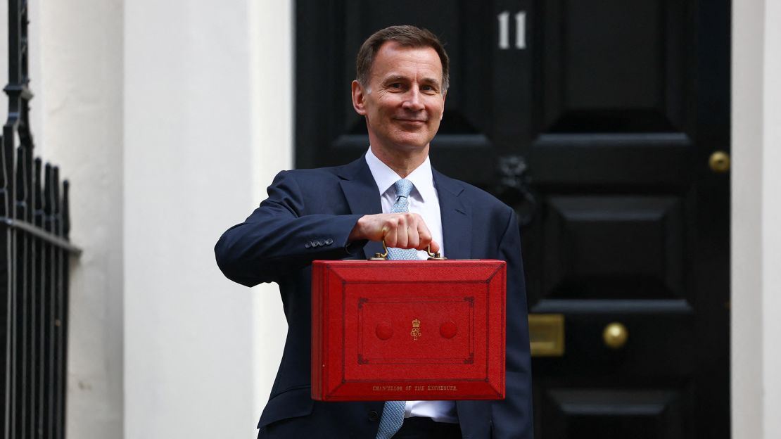 UK finance minister Jeremy Hunt poses with the red budget box outside his office on Downing Street in London on March 6, 2024.