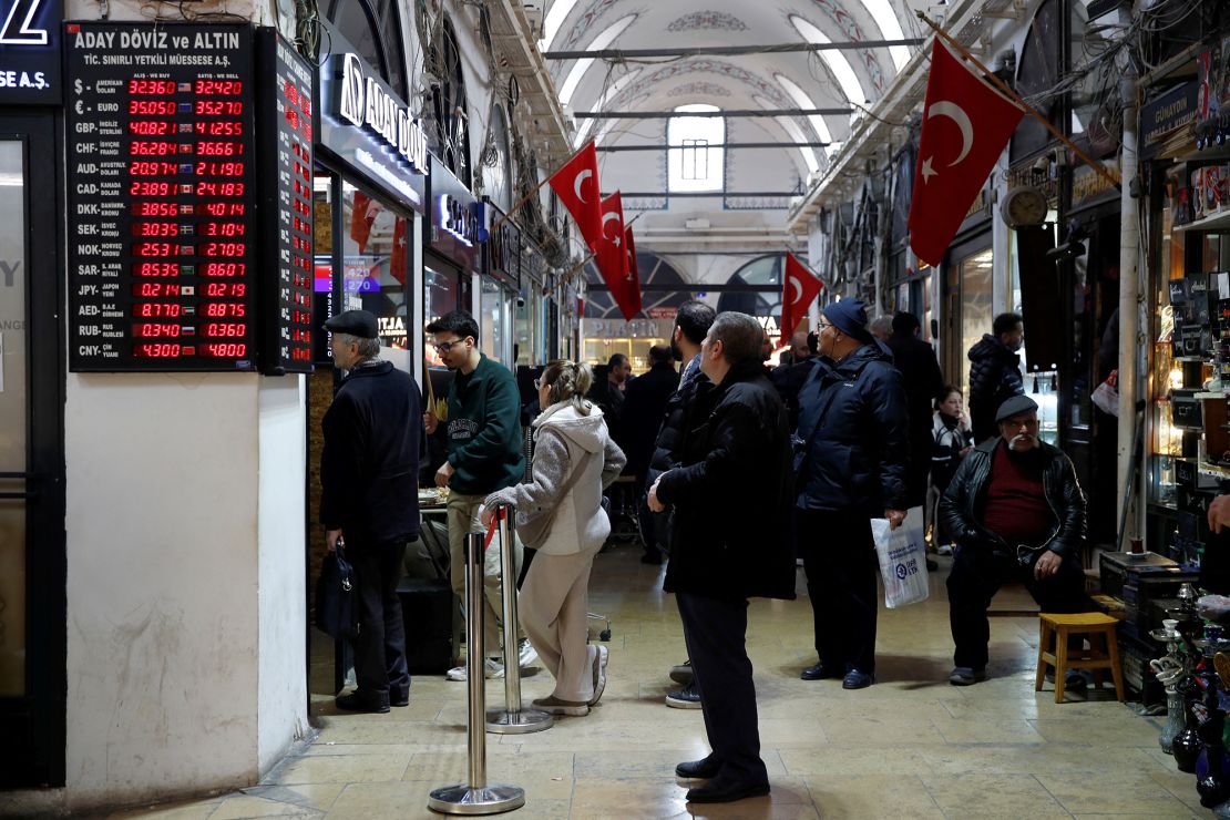 People wait in line outside a currency exchange office at the Grand Bazaar in Istanbul on March 7, 2024.