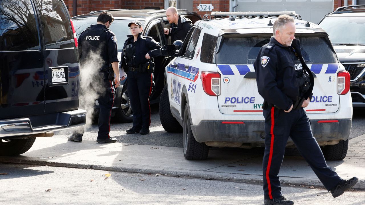 Ottawa Police Service officers surround a home after four children and two adults were found dead inside a neighbouring house in the Ottawa suburb of Barrhaven, Ontario, Canada March 7, 2024.  REUTERS/Blair Gable