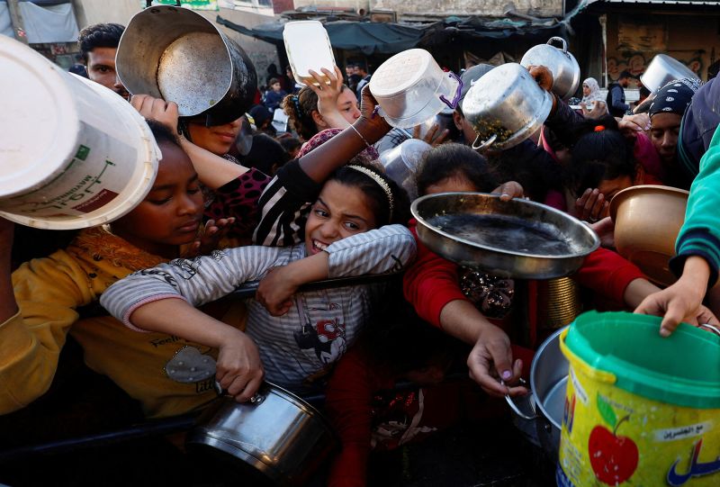 Palestinians wait to receive food as the conflict between Israel and Hamas continues in Rafah, southern Gaza, on March 13.