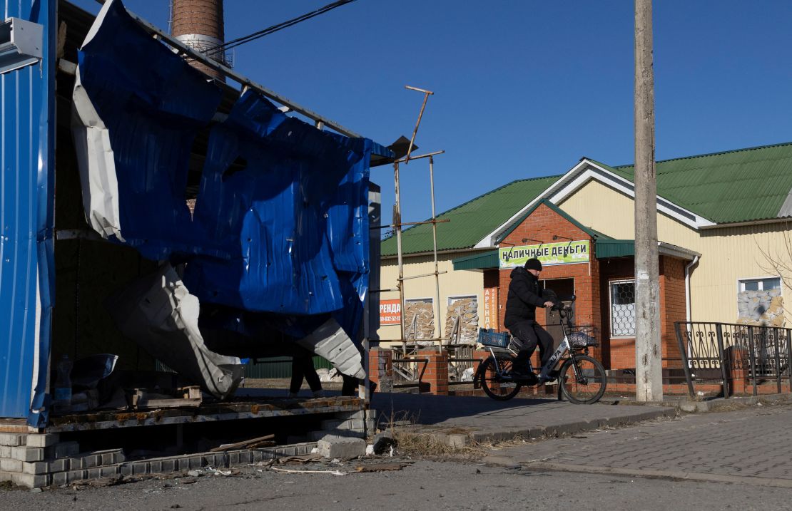 A man rides a bicycle near a damaged market pavilion hit by recent shelling in the town of Shebekino in the Belgorod region of Russia on March 11.