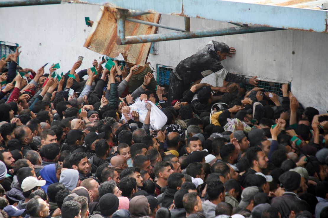 Palestinians gather to receive aid outside an UNRWA warehouse in Gaza, in March.