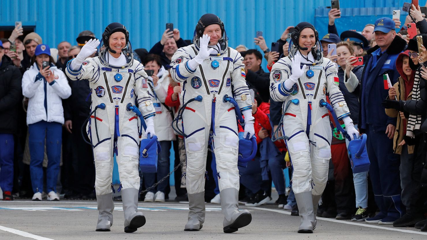 NASA astronaut Tracy Dyson (left) along with Roscosmos cosmonaut Oleg Novitskiy and spaceflight participant Marina Vasilevskaya of Belarus wave toward the crowd while heading to the launchpad at the Baikonur Cosmodrome in Kazakhstan.
