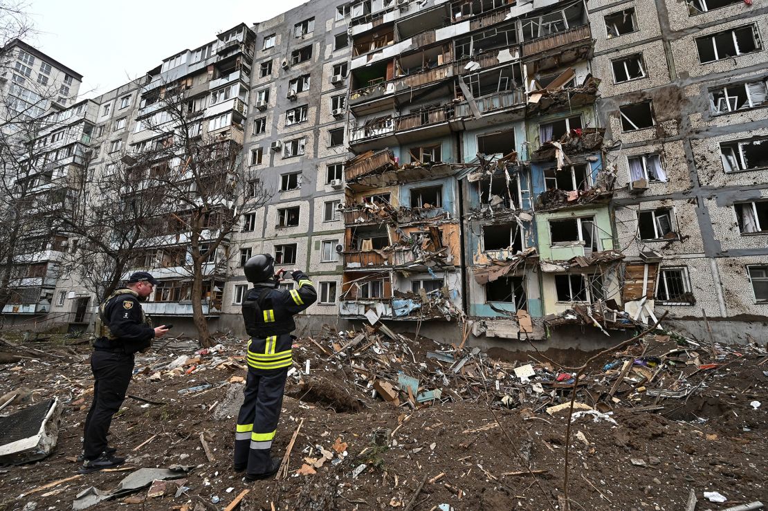 Officials survey the damage to an apartment block in a Russian missile strike in Zaporizhzhia, Ukraine, on March 22, 2024.