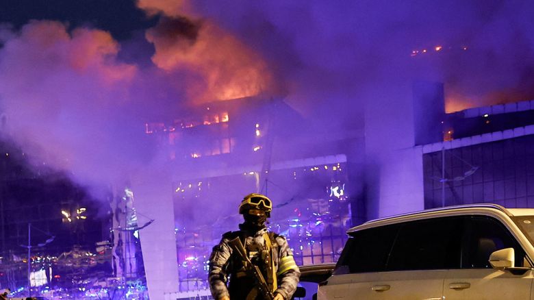 A Russian law enforcement officer near the burning Crocus City Hall concert venue following a shooting incident on March 22, 2024. REUTERS/Maxim Shemetov