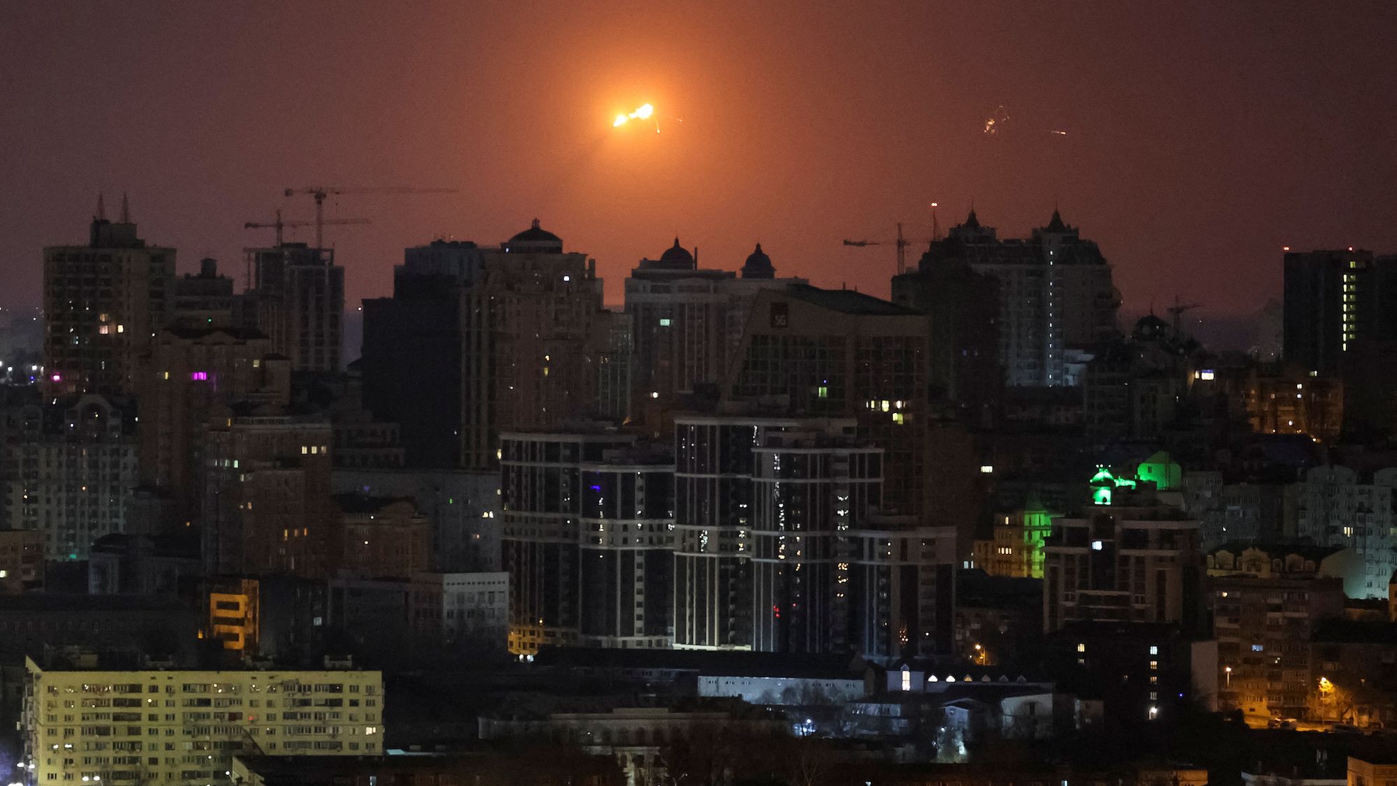 A missile explodes above the Kyiv skyline during a Russian strike.