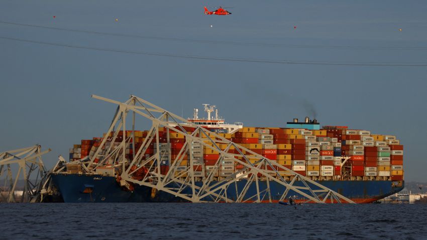 A helicopter flies over Dali cargo vessel which crashed into the Francis Scott Key Bridge causing it to collapse in Baltimore, Maryland, U.S., March 26, 2024.